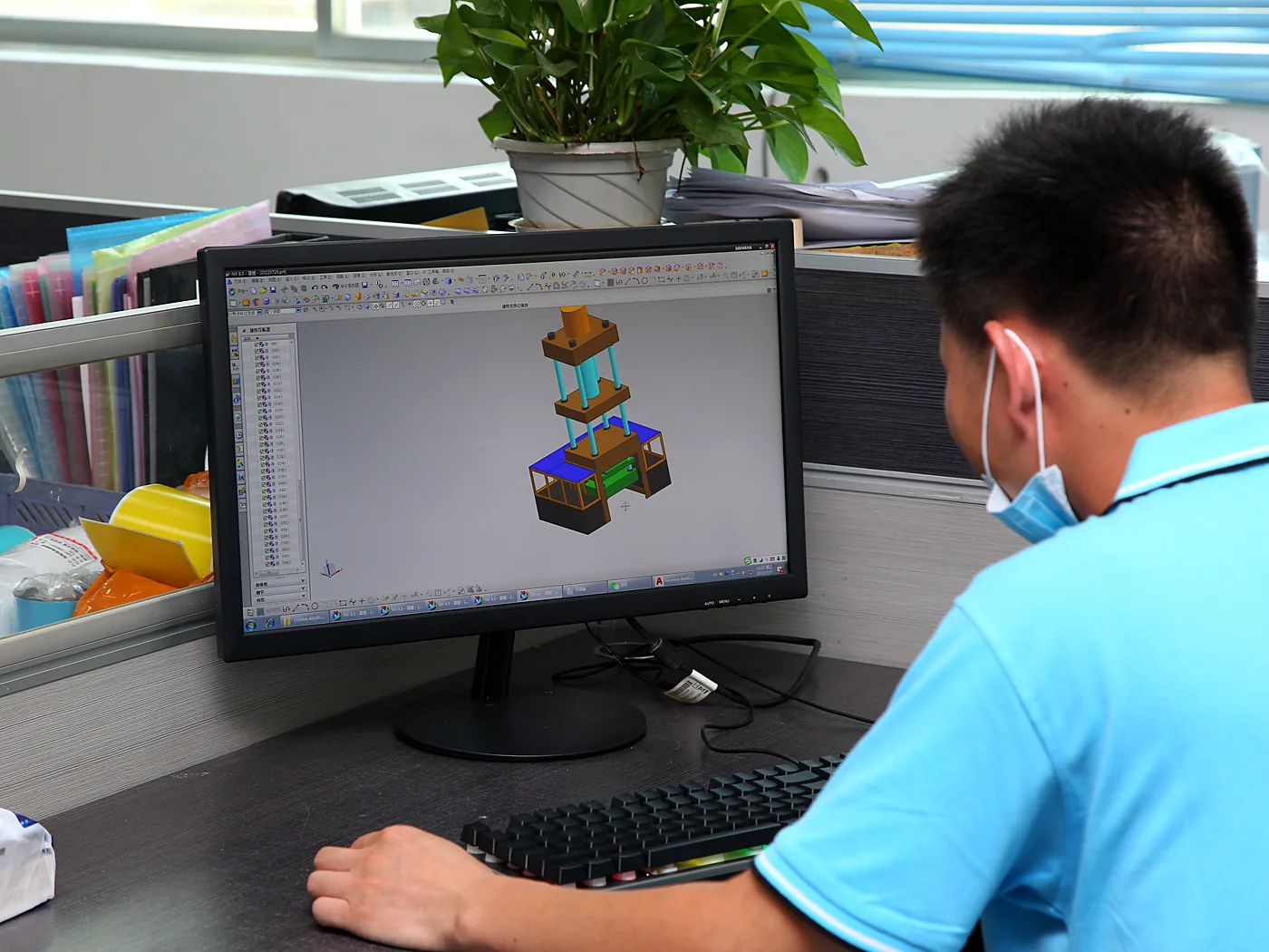 Engineer reviewing a 3D assembly model on a workstation